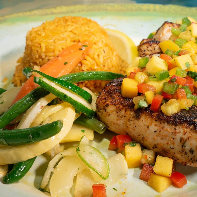 Mahi Mahi blackened fillet topped with tropical salsa, served with veggies and rice.